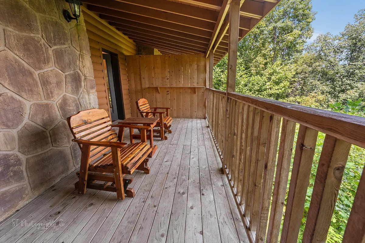 A tranquil corner of the deck adorned with wooden rocking chairs and surrounded by natural greenery, offering a secluded spot for quiet moments and wildlife watching.